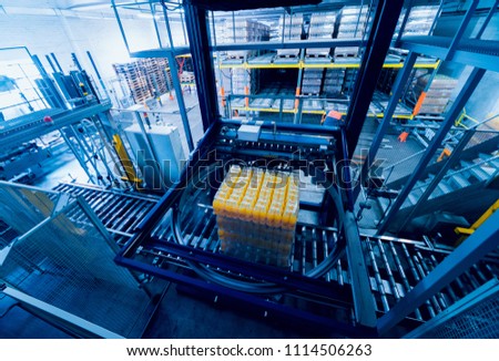 Strapping machine for packaging line. Modern machine for packaging line in factory. Technology and industrial concept. Background