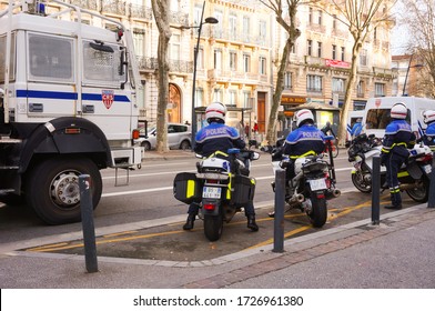 Strasbourg Boulevard, Toulouse, France - Jan. 2020 - Patrol of four motorcyclists riding BMW bikes in front of an anti-riot truck of a crowd-control unit, securing a convoy during a police operation