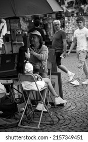 Strasbourg - France - 14 May 2022 - Portrait Of Asian Tourist Posing For A Painter Artist In The Street In Black And White