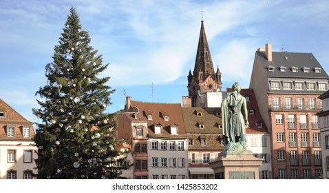 Strasbourg, France - 2012: The Christmas Market (Christkindelsmärik, Les Marchés De Noël) Christmas Tree Stands Beside Statue Of Jean-Baptiste Kléber On Place Kléber In Strasbourg, France.