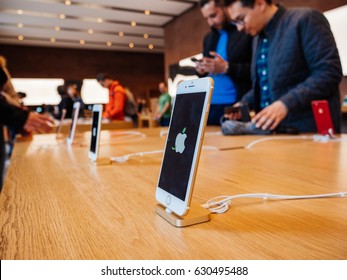 STRASBOURG, FRANCE - APR 27, 2016: Latest iPhone 7 and iPhone 7 Plus in Apple Store with screensaver dedicated to Earth Day  - customers shopping testing in the background 