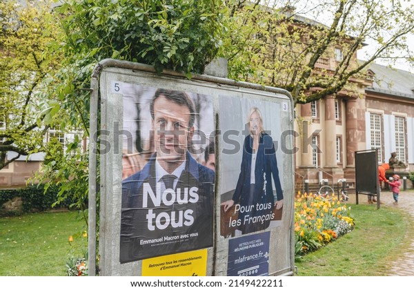 Strasbourg, France - April 24, 2022: Wet\
election posters of Emmanuel Macron and Marine Le Pen during\
Election day in France, posters near Pavillon Josephine people are\
called to choose the\
president