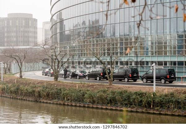 STRASBOURG, FRANCE - DEC 11, 2018: Official\
delegation cars limousine and vans with private drivers wating\
outside the walls of European\
Parliament