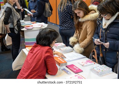 STRASBOURG, FRANCE - FEB 4, 2016: Children and teens of all ages attending annual Education Fair to choose career path and receive vocational counseling - mentor giving advice