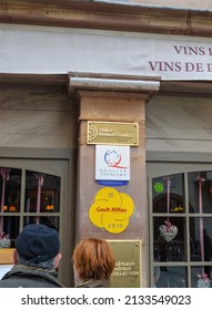 Strasbourg, France - Mar 21, 2015: Rear View Of Couple At The Entrance Of Restaurant With Multiple Signages - Table Remarcable Signage, Gaulat Nad Milau, Quality Tourisme, And Chateus And Hotes