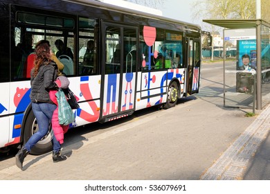 STRASBOURG, FRANCE - MAr 26, 2016: Woman Running To Catch The Bus At The Bus Station In The Suburbs Of Strasbourg, France, Alsace