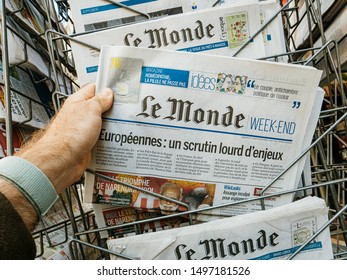 Strasbourg, France - May 18, 2019: POV Man Hand Holding Reading Latest Le Monde Weekend French Newspaper Featuring European Elections On First Page