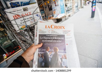 Strasbourg, France - May 27, 2019: Man holding buying La Croix newspaper front page on street press kiosk newsstand with the results of 2019 European Parliament election 