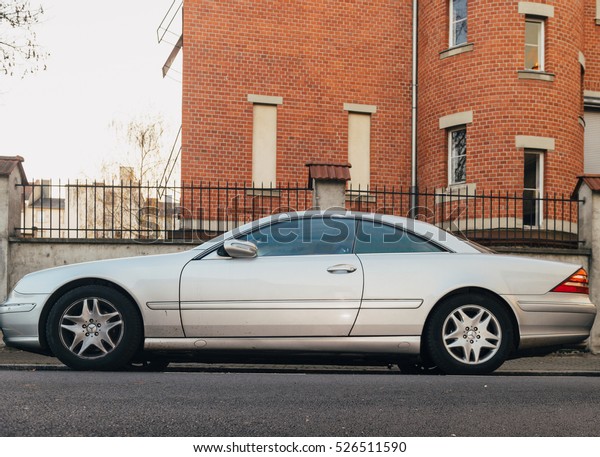 STRASBOURG, FRANCE - NOV 29, 2016: Silver\
Mercedes-Benz CL luxury coupe parked in city with luxury real\
estate building in the\
background