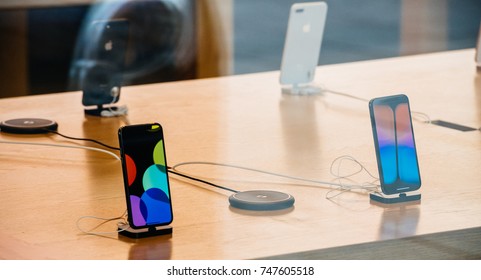 STRASBOURG, FRANCE - NOV 3, 2017: Latest Apple IPhone X Goes On Sale In Apple Store Worldwide - Reflection Of Street In Glass Facade With Phones Inside Next To AirPower Wireless Charging