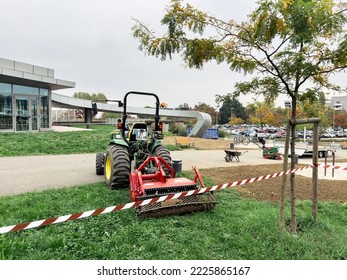 Strasbourg, France - OCt 20, 2022: Rear View Of Tractor Carrying Red Powerful Lipco Lawn Seeder Aerator Stone Burier Ufd For Three Point Suspension