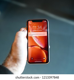 STRASBOURG, FRANCE - OCT 26, 2018: Customer POV Holding New Red IPhone XR Smartphone During The Launch Day Notification Price App