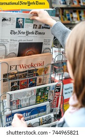 STRASBOURG, FRANCE - OCT 28, 2017: Woman Buying The New York Times Newspaper  Business At Press Kiosk Featuring Article About Nigerian Girls