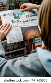 STRASBOURG, FRANCE - OCT 28, 2017: Woman Buying The New York Times Newspaper  Business At Press Kiosk Featuring Article About Nigerian Girls