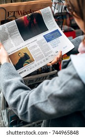 STRASBOURG, FRANCE - OCT 28, 2017: Woman Buying Reading The New York Times Newspaper At Press Kiosk Featuring Colin Farrell Article 