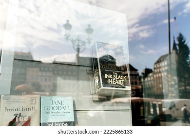 Strasbourg, France - Oct 28, 2022: Reflection Of City Center With The Ink Black Heart Book By Robert Galbraith In Book Store Showcase