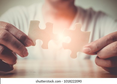 Strategic management and business solutions for success, Hand of male connecting jigsaw puzzle