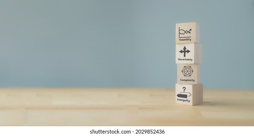 Strategic management and VUCA concept. Wood cube VUCA icon and text; volatility, uncertainty, complexity, ambiguity with grey background. The modern management for new trend and rapid transition. 