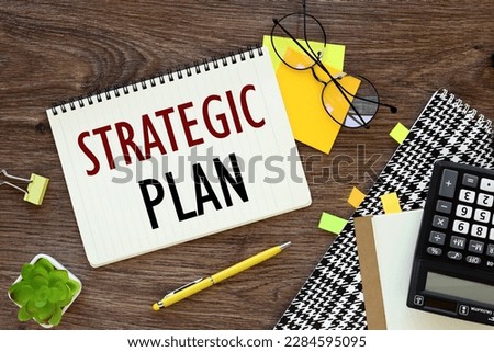 STRATEGIC PLANNING text. Notepad, white sticker and pensil on the desk.