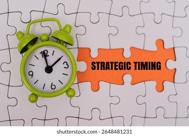 STRATEGIC TIMING word alphabet letters on puzzle next to green alarm clock. Representing time management, strategy and achieving goals