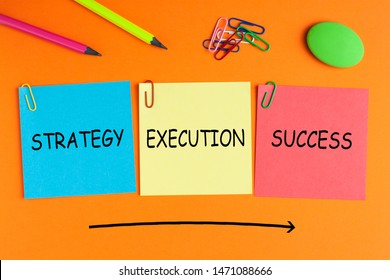 Strategy Execution Success text on notes pasted on orange background with a big arrow and office supplies.