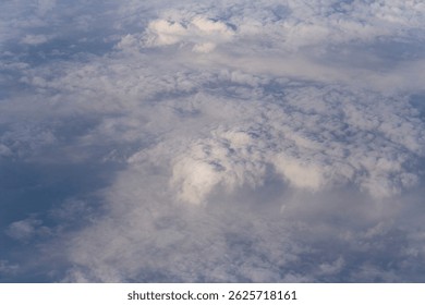 Stratosphere, a view of clouds from an airplane window.  Cumuliform cloudscape on sky. Flying over the land.