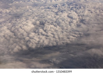 Stratosphere, view of the earth through clouds. Seascape, top view, from the airplane window. - Shutterstock ID 1310483399