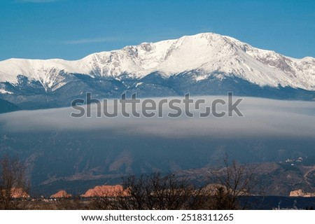 A stratus cloud formation hangs low in front of Pikes Peak on an early spring day. These are low-altitude clouds that can indicate rain or fog.