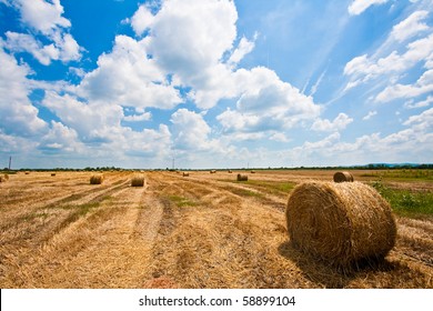 Straw Bale  / Hey Stack On Sunny Day With Big Clouds.