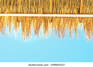 Straw Beach Umbrella Against A Blue Sky. Grass roofs. - Powered by Shutterstock
