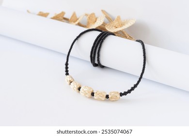 Straw and bead necklace, and black beaded bracelet on a white background. Black beaded.  - Powered by Shutterstock