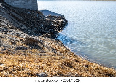 Straw Covered Slope Leading To A Stormwater Retention Basin Used To Control Soil Erosion At A Construction Site 