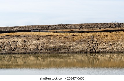 Straw Covered Slope Leading To A Stormwater Retention Basin Used To Control Soil Erosion At A Construction Site 