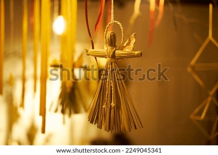 A straw doll hangs as a decoration in the house. Traditions of Slavic countries. Horizontal photo. Empty space in the image.