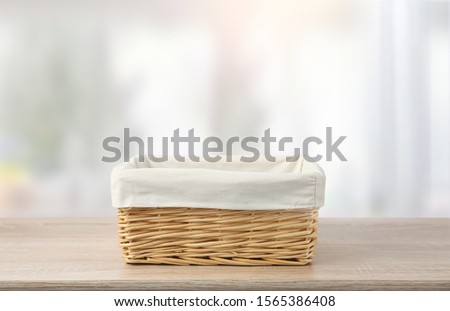 Straw empty basket decorated with white linen on wooden table,food advertisement template.Container.
