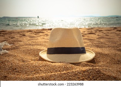 Straw Fedora Hat On Sandy Beach 