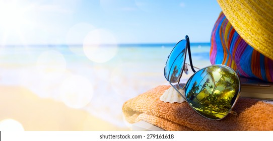 Straw hat, bag and sun glasses  on a tropical beach  - Powered by Shutterstock