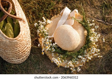 A Straw Hat Decorated With A Wreath Of Daisies. Bag Of Corn Cobs