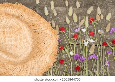 straw hat and different flowers and ears of corn on rough wooden background. flat lay top view - Powered by Shutterstock