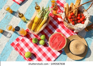 Straw Hat And Different Products For Summer Picnic On Checkered Blanket, Flat Lay