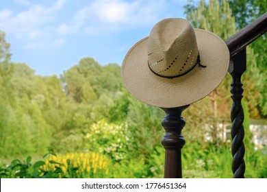 Straw Hat Hanging In The Green Garden. Selective Focus