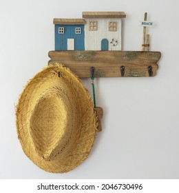 Straw Hat Hanging On Wooden Scrap Wood Coat Rack With Small Houses, Rustic Style Interior