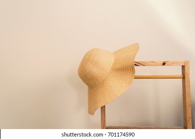 straw hat hanging on wooden stand with white wall background, vintage color tone - Powered by Shutterstock