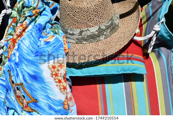 Straw hat and\
Hawaiian shirt on a\
hammock