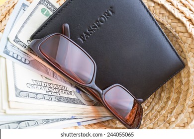 A Straw Hat With A Leather Passport Holder, Sunglasses And Vacation Cash.