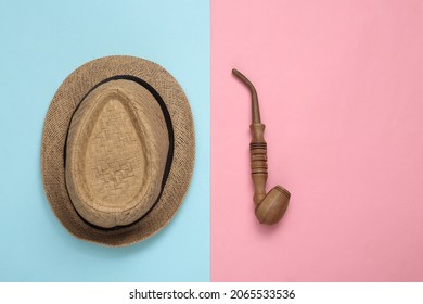 Straw Hat With Smoking Pipe On Pink Blue Background. Top View