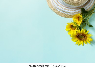 Straw Hat And Sunflowers On Pastel Green Background. Summer Holiday, Vacation Concept. Flat Lay, Top View, Copy Space.