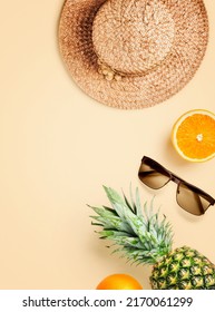 Straw hat, sunglasses, orange and pineapple fruit on bright background. Summer vacation creative layout. Flat lay, top view. Greeting card