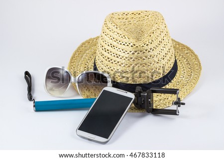 straw hat with sunglasses and smartphone and equipment selfie on white background / Handmade straw hat on white.