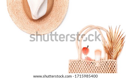 Straw hat, wicker macrame bag, sunblock, golden palm branch and red sunglasses isolated on white background. Copy space. Summer holiday accessory